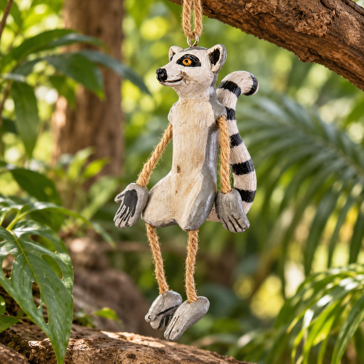 Bert Anderson ring-tailed lemur ornament with dangly rope arms and legs hanging in a lush tropical habitat