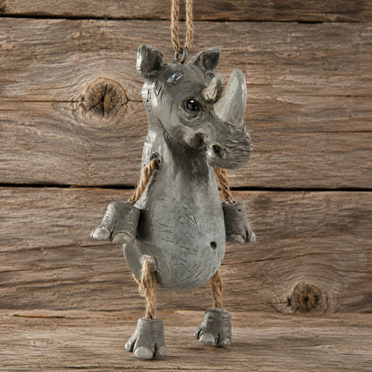 A gray rhinoceros hanging ornament with rope details and a hanging loop, shown against a rustic wooden plank background.