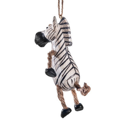 Back view of a hanging zebra figurine with a white body, black stripes, black hooves and nose, and a brown rope tail and hanging loop, shown on a plain white background.