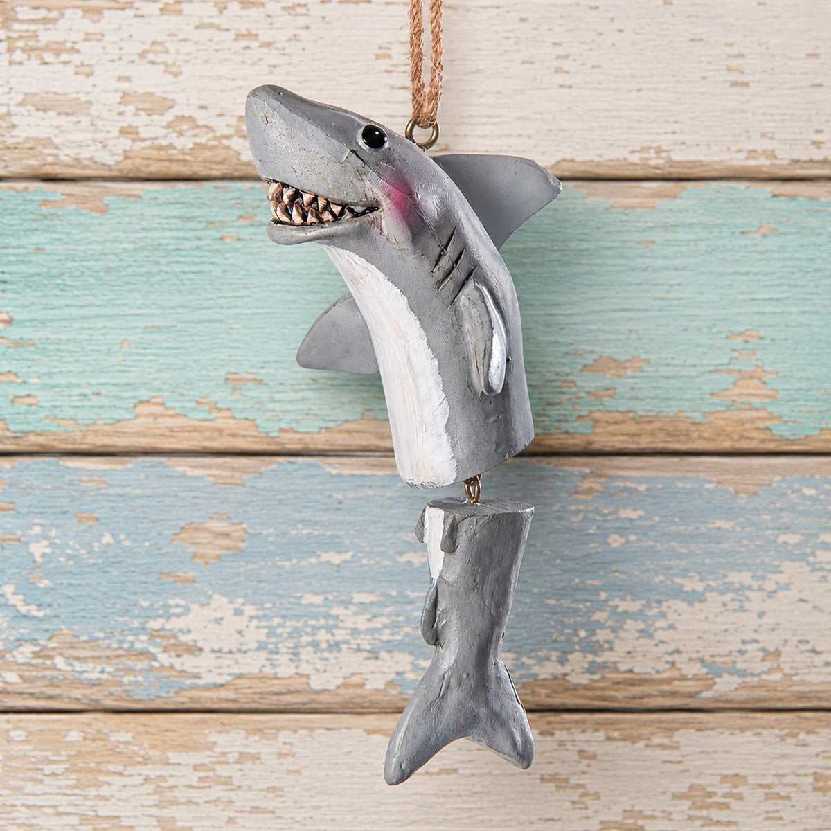 A shark hanging ornament with a jointed tail and jute hanger.  Designed by artist Bert Anderson