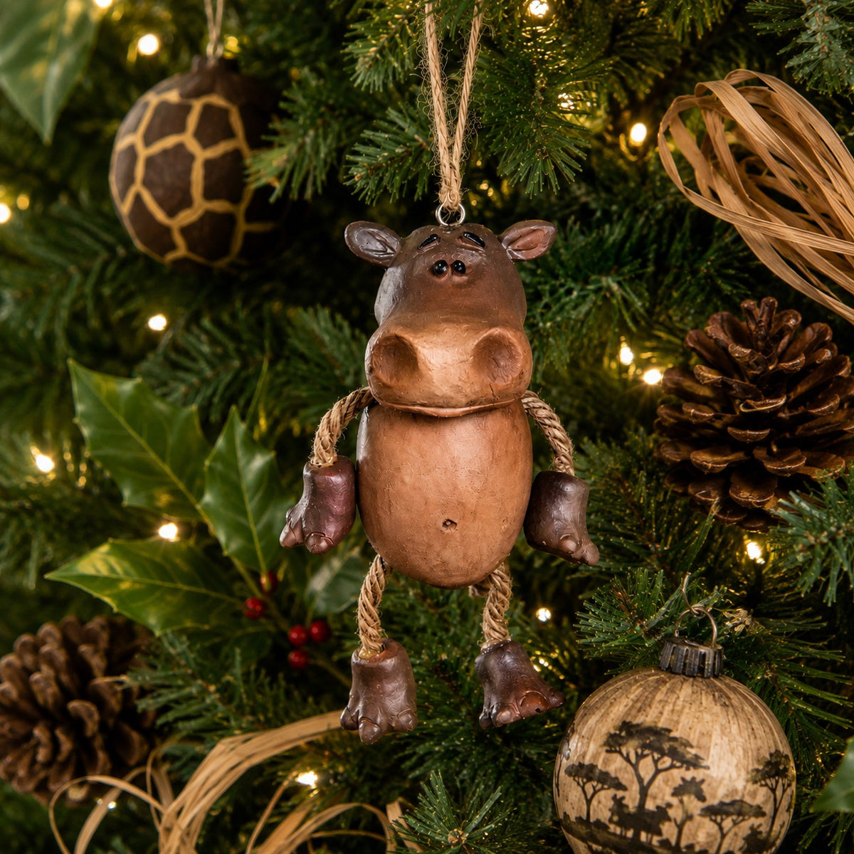 A rustic brown resin hippo ornament with dangly arms and legs and jute hanger.  By Bert Anderson