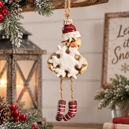 A hanging Snowman Ornament with striped leggings, red hat and carrying  a snowflake.   Winter home decor.