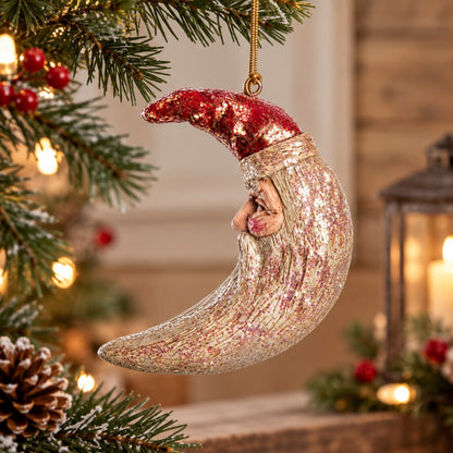 Bert Anderson crescent moon Santa ornament with shimmering finish displayed in warm Christmas home décor with lights and greenery.