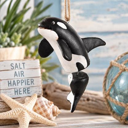 Bert Anderson orca killer whale ornament with dangling tail displayed in coastal home décor with driftwood, starfish, seashells and a glass fishing float.