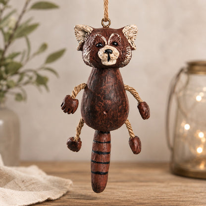 Whimsical red panda ornament with dangly rope arms and legs. Decorative home background.
