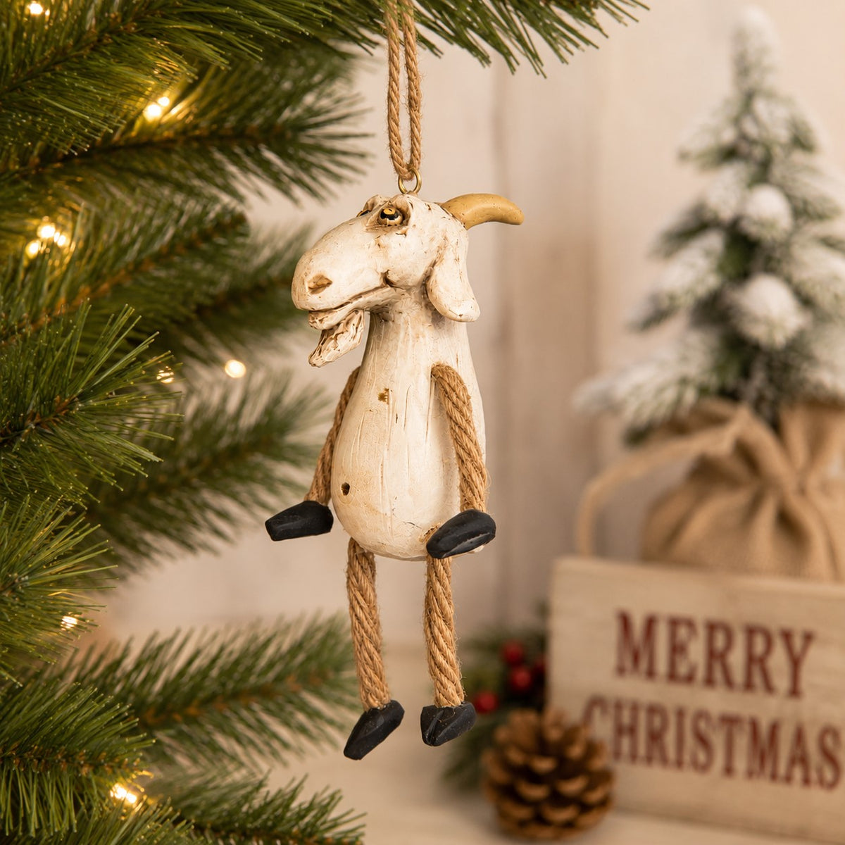 Whimsical goat ornament with rope arms and legs.  Displayed on a Christmas tree with holiday decor.  By Bert Anderson
