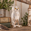 Bert Anderson snowy owl ornament with yellow eyes and dangling rope legs displayed in rustic nature-inspired décor.