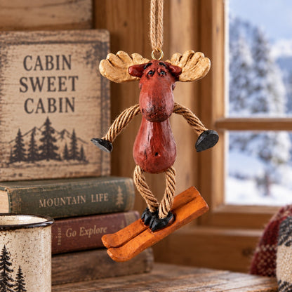 Bert Anderson skiing moose ornament hanging in cozy mountain lodge décor with a snowy window in the background