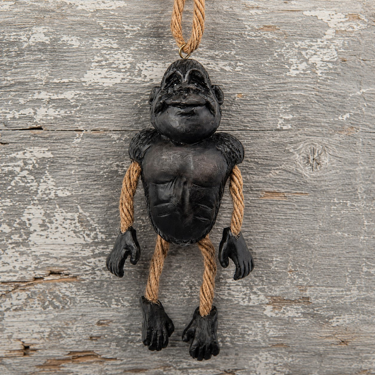 Gorilla Ornament with dangly rope  arms and legs displayed on a rustic board background.