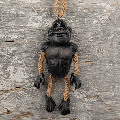 Gorilla Ornament with dangly rope  arms and legs displayed on a rustic board background.