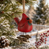 Cardinal ornament hanging from  a pine tree with red berries.  By artist Bert Anderson