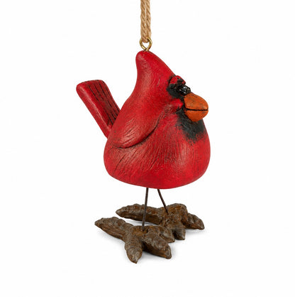 A red cardinal oranament with wire legs, hanging from a jute rope shown on a white background.