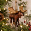 Rustic moose ornament  hanging from a Christmas tree with a festive holiday decor.
