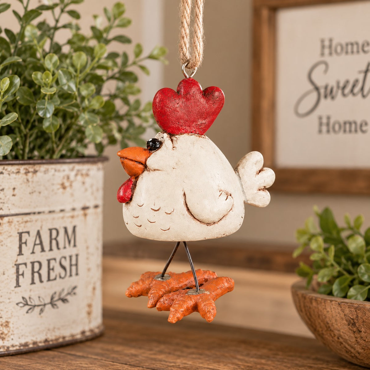 Bert Anderson white chicken ornament with wire legs hanging in a warm farmhouse kitchen setting with rustic décor and greenery.