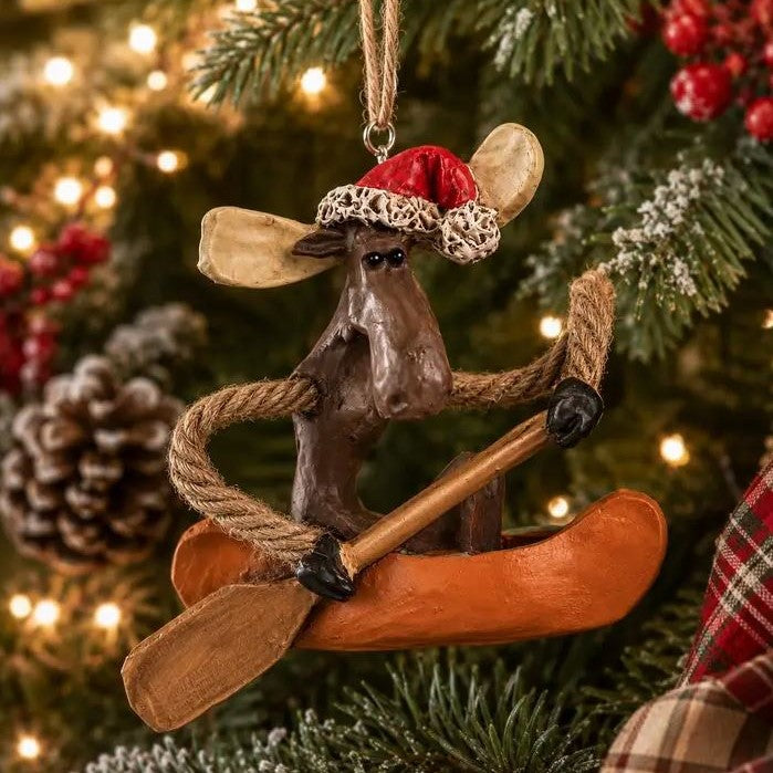 Bert Anderson Moose in canoe Santa ornament with a hanging on Christmas tree.