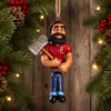 Paul Bunyan Ornament by Bert Anderson   
Featuring a traditional lumberjack style with a red shirt, blue pants, and a silver axe, hanging against a wooden background. 