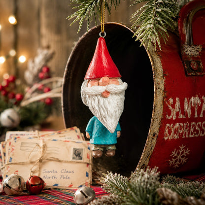 Bert Anderson gnome ornament with red pointed hat, white beard and blue coat displayed in a nostalgic Christmas setting with greenery and vintage holiday décor.