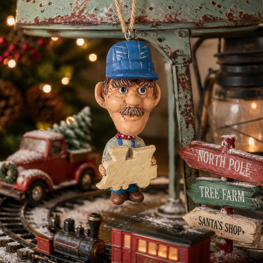 Bert Anderson train conductor ornament displayed in a nostalgic Christmas train setting with miniature locomotive, holiday greenery and vintage décor.