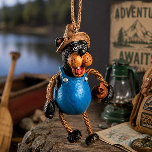 Bert Anderson Moonshine  Bear Ornament.  Outdoors at the lake this black bear has blue coveralls,  a fishing hat and whiskey jug in his hand.