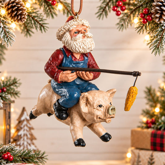 Bert Anderson Santa riding a pig Christmas ornament with a dangling ear of corn, displayed against a light holiday background with evergreen, red berries and warm lights.
