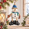 Bert Anderson snowman ornament with blue hat, scarf, rope legs and oversized black boots displayed in a bright Christmas setting.