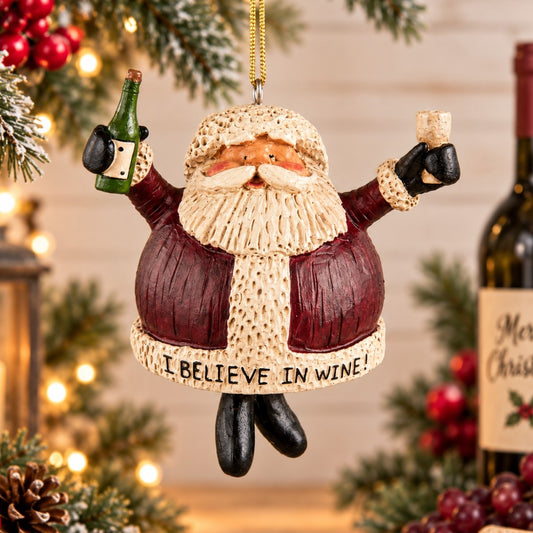 Bert Anderson Santa wine ornament holding a wine glass beside a wine barrel with grapes and “I Believe in Wine” displayed in a festive Christmas home décor setting.