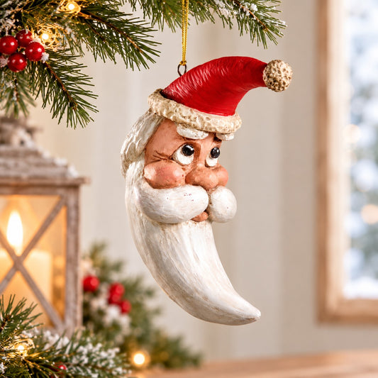 Bert Anderson crescent moon face ornament with red hat and flowing white beard displayed in a bright, simple holiday setting with soft Christmas lights