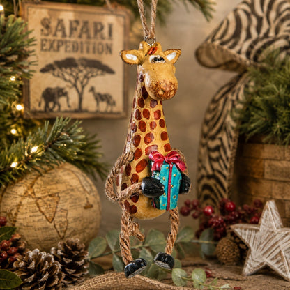 Giraffe Christmas ornament.  Giraffe is holding a present.  Safari home decor background.