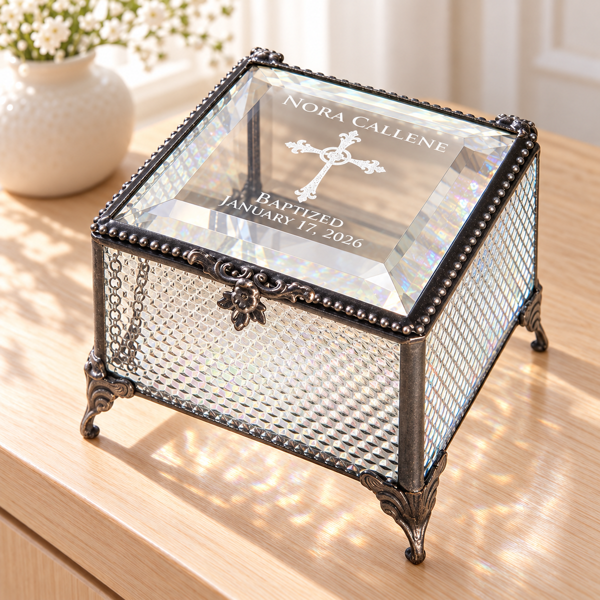 Clear textured glass baptism keepsake box engraved Nora Callene, an ornate cross, Baptized and January 17, 2026, with a clear beveled lid and decorative feet.