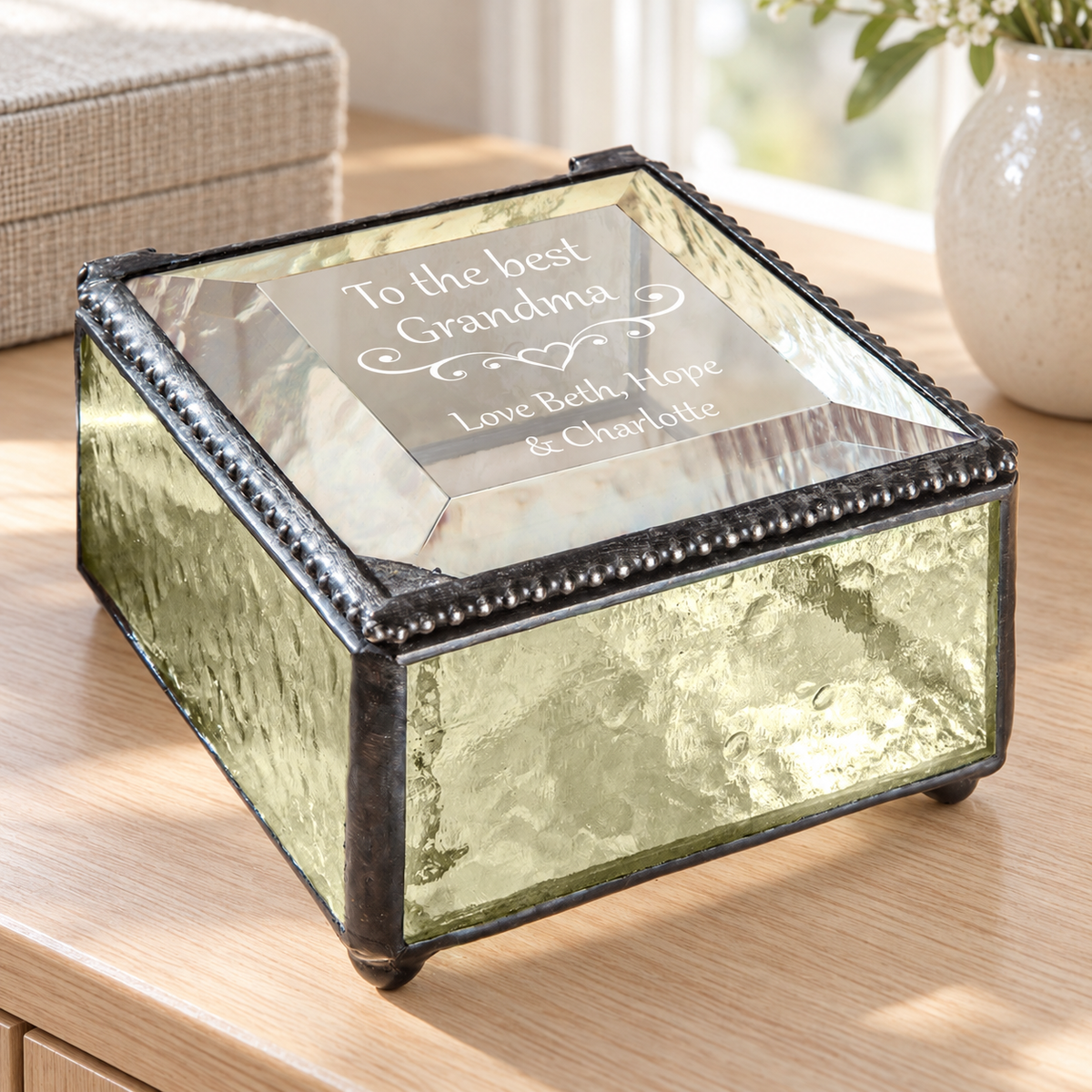 J Devlin pale antique yellow glass Grandma keepsake box with a clear beveled lid, heart scrollwork, and “To the best Grandma, Love Beth, Hope & Charlotte” engraving.