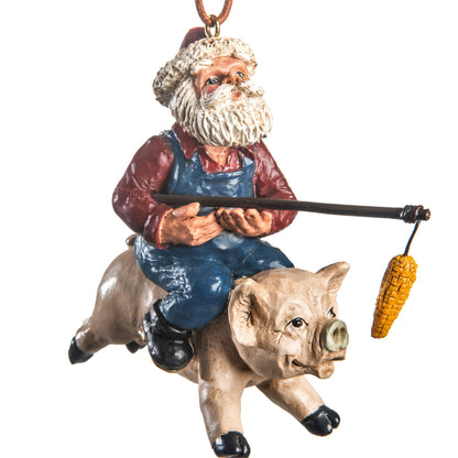 “Santa riding a flying pig ornament with blue overalls, red shirt and dangling ear of corn by Bert Anderson.”